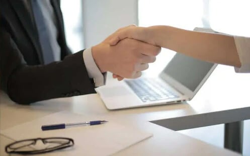 Two people shaking hands on a photocopier rental agreement